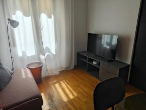un soggiorno con divano e TV a schermo piatto di Fluère - Via Riva Reno a Bologna