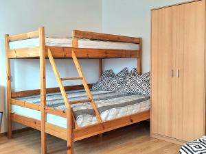 a wooden bunk bed with a ladder in a room at Zacisze Apartamenty,Pokoje in Wicie