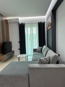a living room with a couch and a tv at Gael Apartment in Berat