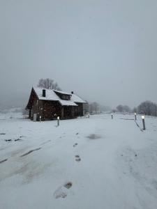 un fienile ricoperto di neve con impronte nella neve di Kuća za odmor Toma a Prvan Selo