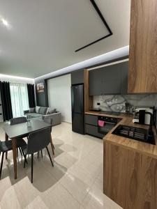 a kitchen and living room with a table and a couch at Gael Apartment in Berat