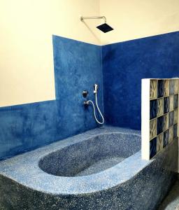 a blue bathroom with a tub with a shower at HA Beach Boutique - Adults Only in Jambiani