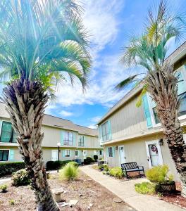 two palm trees in front of a building at The Blue Crab in Myrtle Beach
