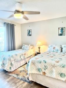a bedroom with two beds and a ceiling fan at The Blue Crab in Myrtle Beach +35 photos