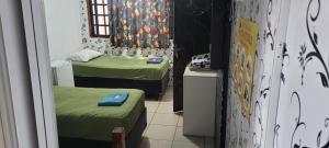 a small room with two beds and a window at Hotel Toka do Skillo in Arujá
