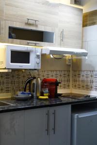 a kitchen with a sink and a microwave at studio au cœur d'Alger centre in Sidi MʼHamed