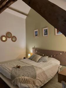 a bedroom with a large bed with a wooden headboard at Bourlidou in Combourg +10 photos