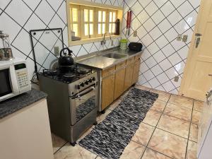 una cucina con fornelli e lavello di Chalé Condomínio Vila Suiça - Balneário Rincão a Vila Nova Altre 15 foto