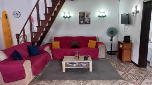 a living room with a red couch and a table at Quinta da Baldaia in Rabo de Peixe