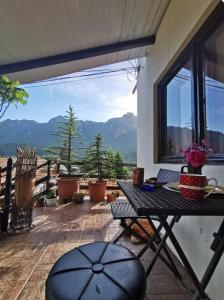 a balcony with a table and a view of the mountains at Apartament Casa cu Flori de Munte in Buşteni