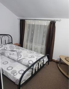 a bed in a room with a window at Apartament Casa cu Flori de Munte in Buşteni