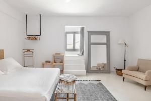 a bedroom with a bed and a chair and a mirror at Horizon House with private pool and breathtaking views in Andiparos