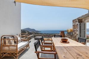 a wooden table and chairs on a patio with a view of the ocean at Horizon House with private pool and breathtaking views in Andiparos