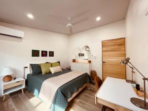 a bedroom with a bed and a desk and a table at Casa Tres Luces - Samara Home in Nicoya +23 photos