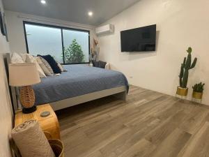 a bedroom with a bed and a flat screen tv at Casa Tres Luces - Samara Home in Nicoya