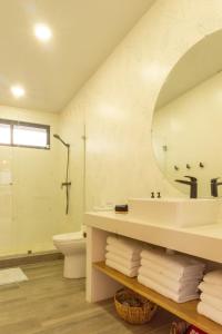 a bathroom with a sink and a toilet and a mirror at Casa Tres Luces - Samara Home in Nicoya