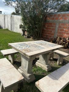 una mesa de picnic de piedra con un mosaico en ella en Alojamiento Gala, en Villa Elisa 1 foto más
