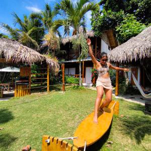 a woman is standing on a surfboard at Montañita Cabañas in Montañita +25 photos