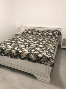 a bed with a black and white blanket on it at Villa Bacchus in Nikiti