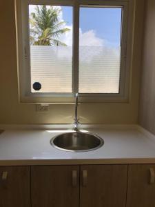a sink in a kitchen with a window at Aruba IXORA Suites in Noord