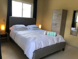 a bed with white sheets and pillows in a bedroom at Aruba IXORA Suites in Noord