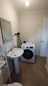 a bathroom with a washing machine and a sink at arriendo casa independiente en Valdivia in Valdivia +13 photos