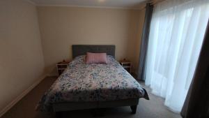 a bedroom with a bed with a pink pillow on it at arriendo casa independiente en Valdivia in Valdivia