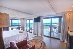 a bedroom with a bed and a view of the ocean at One Beach Boutique Hotel in Morro de São Paulo