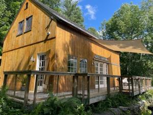 a large wooden house with a porch at Sadawga Springs Retreat in Whitingham