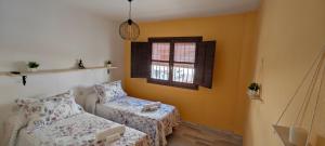a room with a bed and a chair and a window at La Casita de Juana in Málaga