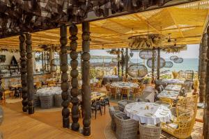 a restaurant with white tables and chairs and the ocean at Green Line Villa Sozopol in Sozopol