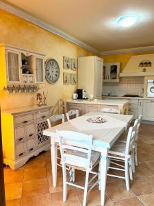a kitchen with a table and chairs and a clock on the wall at Casa Lala in Palau +25 photos