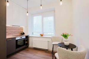a kitchen with a table and chairs and a window at King Mindaugas center apartment in Kaunas