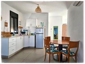 a kitchen with a table and a refrigerator at ליד המעיין in Lahavot HaBashan