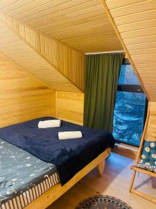 メスティアにあるWooden huts In Mestia-Hut for 14の窓付きの木造の部屋のベッド1台