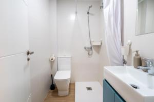 a white bathroom with a toilet and a sink at Casa centro Almedina in Almería