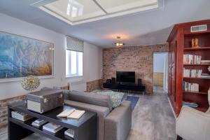 a living room with a couch and a tv at Quebec Grand Appartement by Hébergements DCL in Quebec City