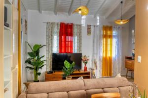 - un salon avec un canapé et des rideaux colorés dans l'établissement villa bouginvillier, à Pointe-Noire