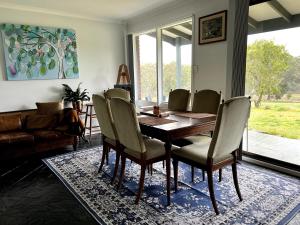 a dining room with a wooden table and chairs at Cyan Farm in Mount Torrens