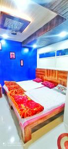 a bedroom with a large bed in a blue room at Shree Sampatbai yatri ghar in Ujjain