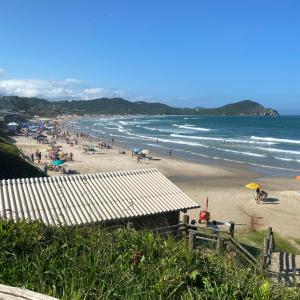 a group of people on a beach with the ocean at Rosa blue in Imbituba