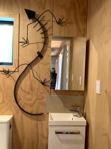 汉密尔顿Boutique Country Retreat -Outdoor bath的带水槽和挂钟的浴室