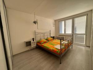 布拉迪斯拉发Apartmán Zuzana的卧室里有一张床，床上铺着色彩鲜艳的被子