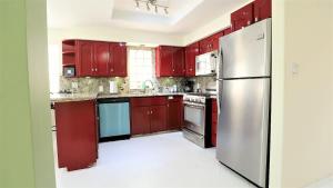 a kitchen with red cabinets and a stainless steel refrigerator at Tijuana Beach View & Patio in Tijuana
