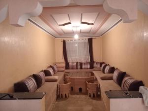 a waiting room with a long couch and chairs at Billa appart in Midelt