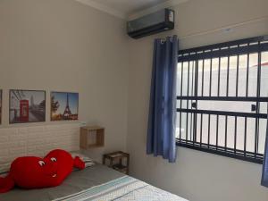 a red heart pillow sitting on a bed in a bedroom at Casa do amor, vc pode ir andando até a praia in Itapoa