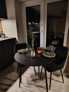 a black table with glasses and a bottle on it at Comfort Apartment in Lone Only 20 minutes away from the heart of the city! in Bergen