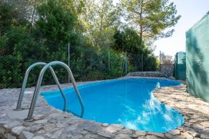 Una piscina con agua azul en un patio. en Casa Calafell, en Segur de Calafell