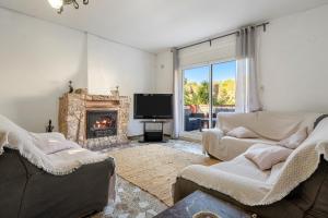 Una sala de estar con dos sofás y una chimenea. en Casa Calafell, en Segur de Calafell