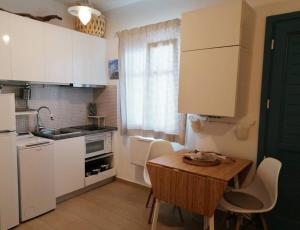 a small kitchen with a wooden table and white cabinets at Studio Blue Sky in Tripiti